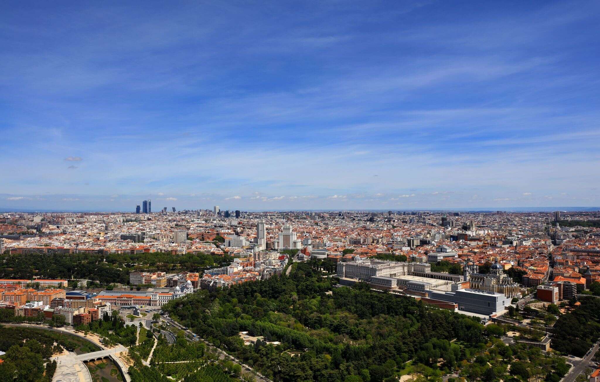 Vista aérea de Madrid con el Palacio Real y los jardines del Campo del Moro en primer plano y las Cuatro Torres al fondo