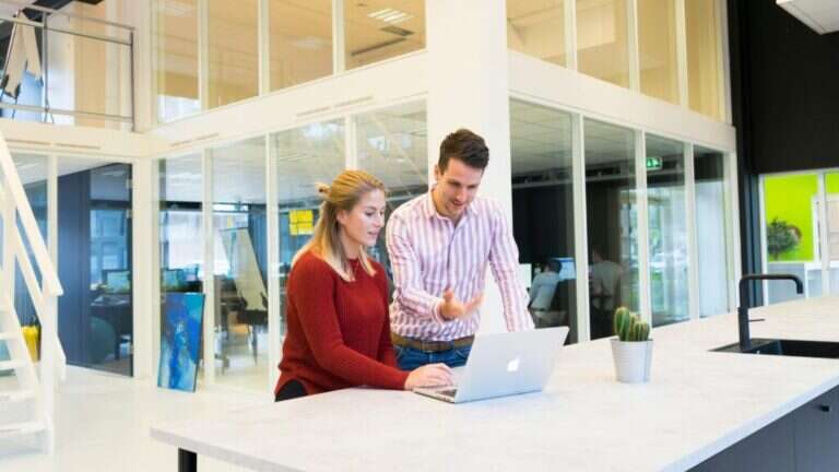 Dos personas trabajando en una oficina diáfana