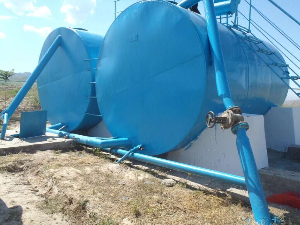 Dos depósitos metálicos de almacenamiento de agua con sus tuberías y válvulas