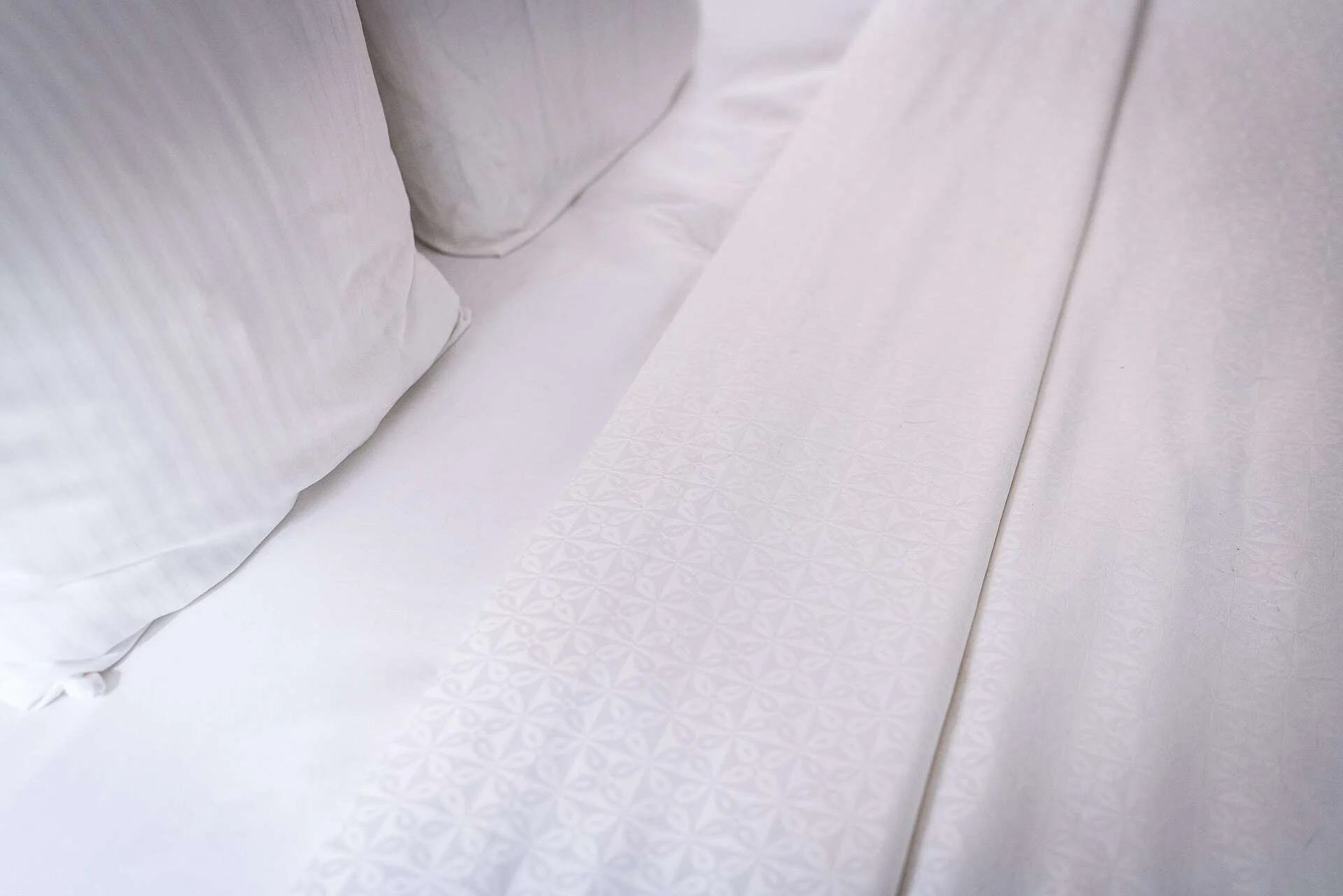 Sábanas y almohadas blancas en la cama de un hotel
